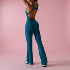 Person wearing a teal jumpsuit on a pink background