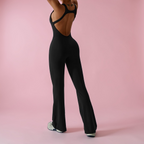 Person wearing a black jumpsuit on a pink background