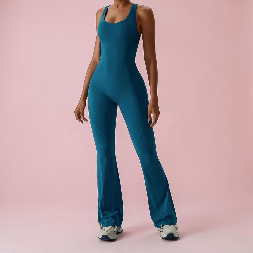 Teal jumpsuit worn by a model on a pink background