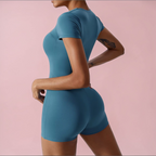 Person wearing a blue athletic outfit on a pink background
