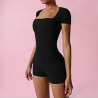 Black bodysuit worn by a model on a pink background