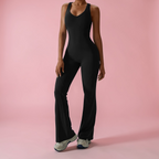 Person wearing a black jumpsuit on a pink background