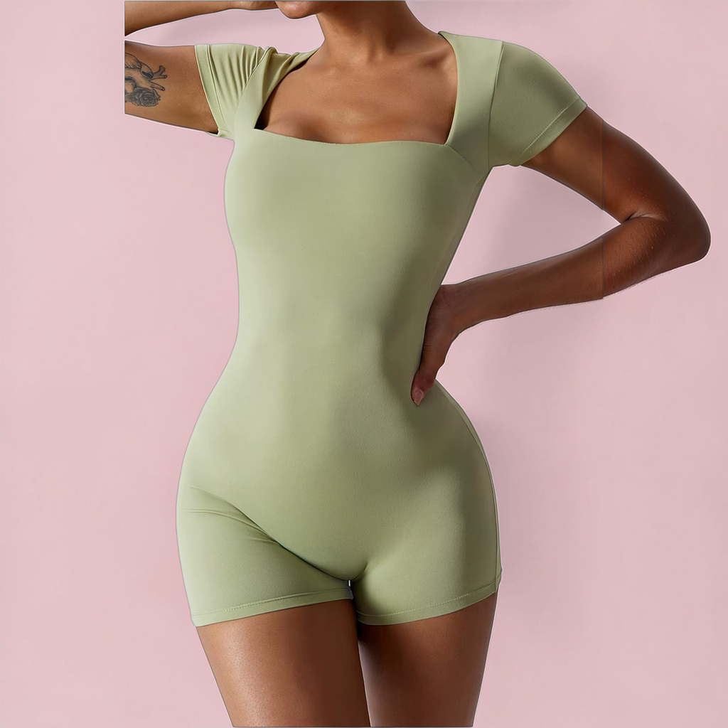 Person wearing a green bodysuit against a pink background