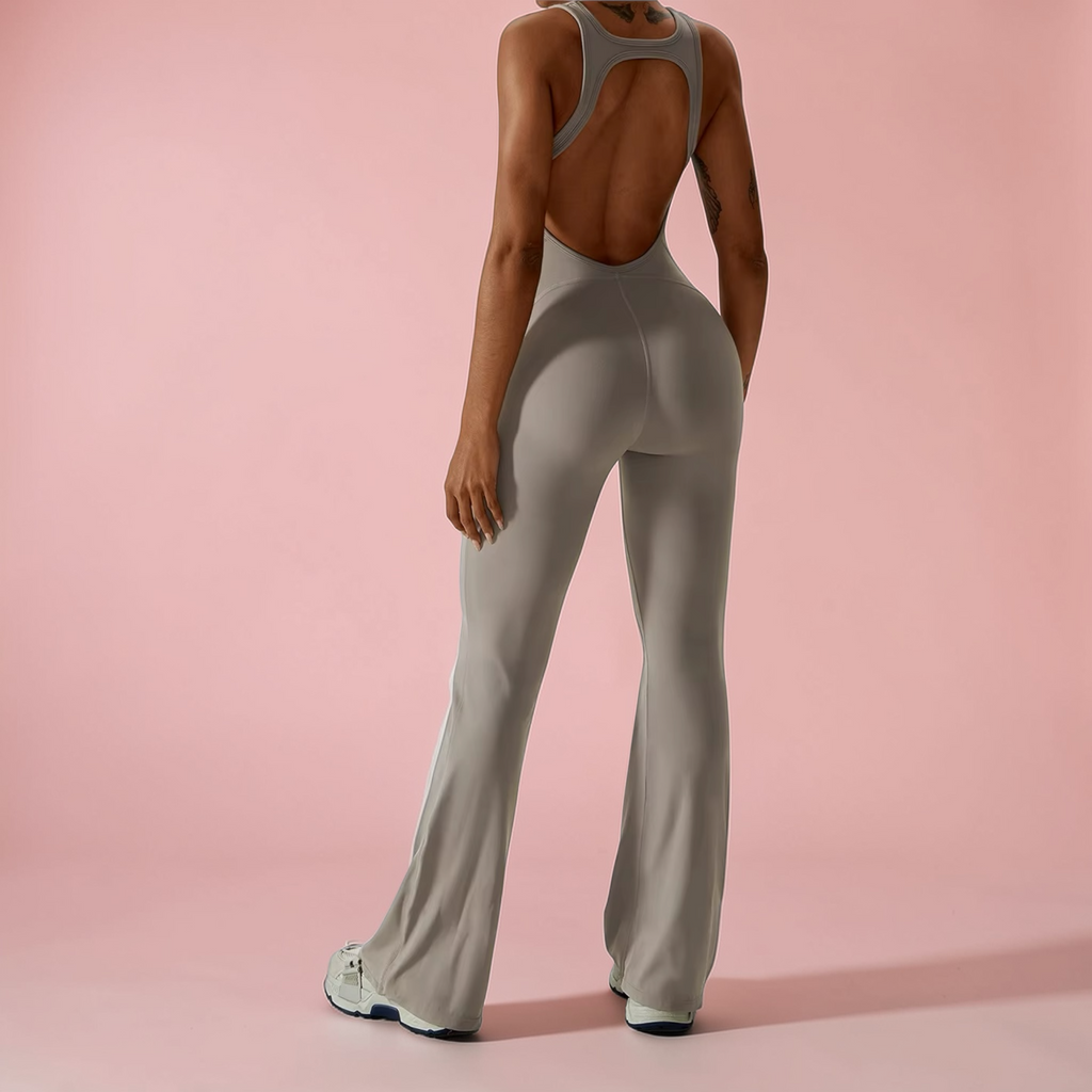 Person wearing a gray jumpsuit on a pink background