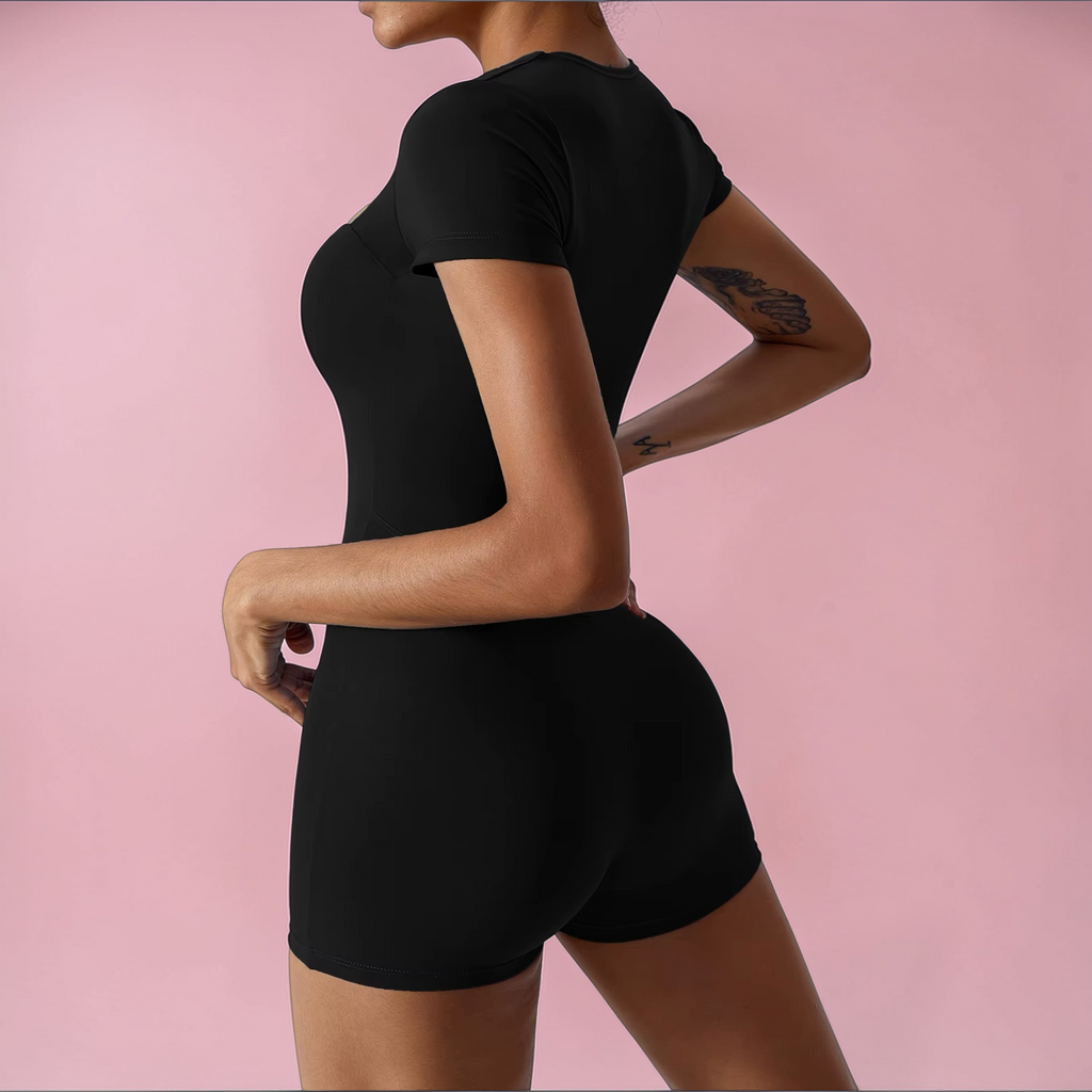 Person wearing a black athletic outfit on a pink background