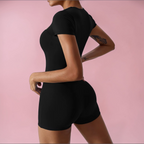 Person wearing a black athletic outfit on a pink background