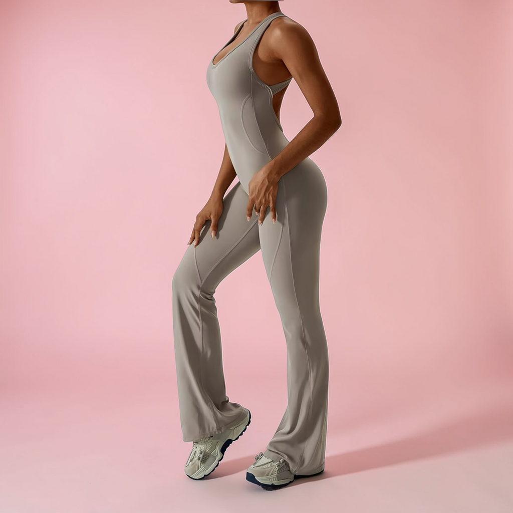 Person wearing a gray jumpsuit on a pink background