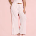 Light pink lounge pants worn by a person on a pink background