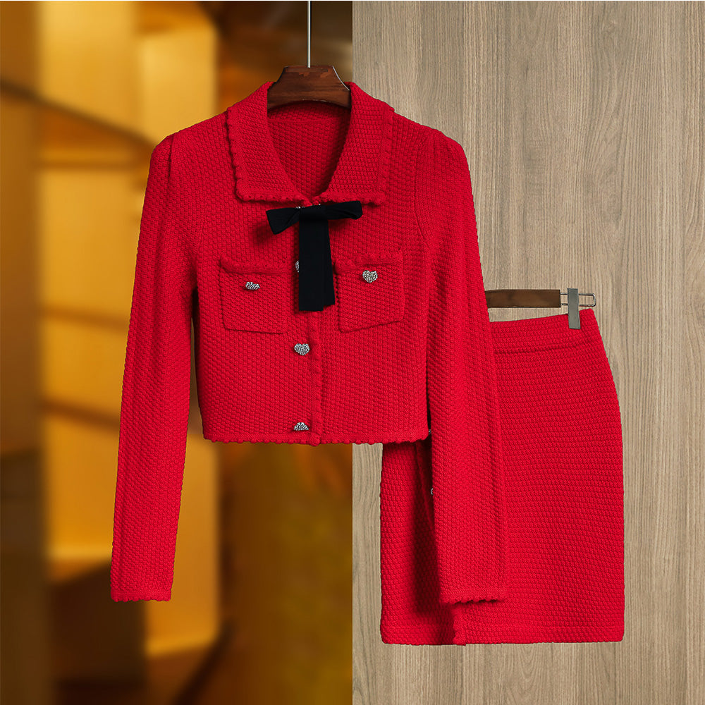 A bright red 2-piece skirt set with a bow sweater top and mini design lady knitted suits, displayed on a hanger.